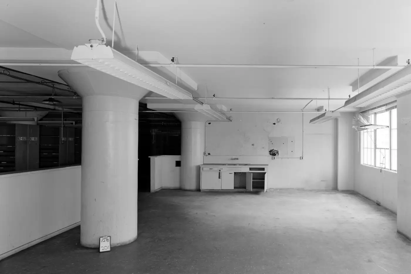 An open office floor with a single column, from an archival building survey