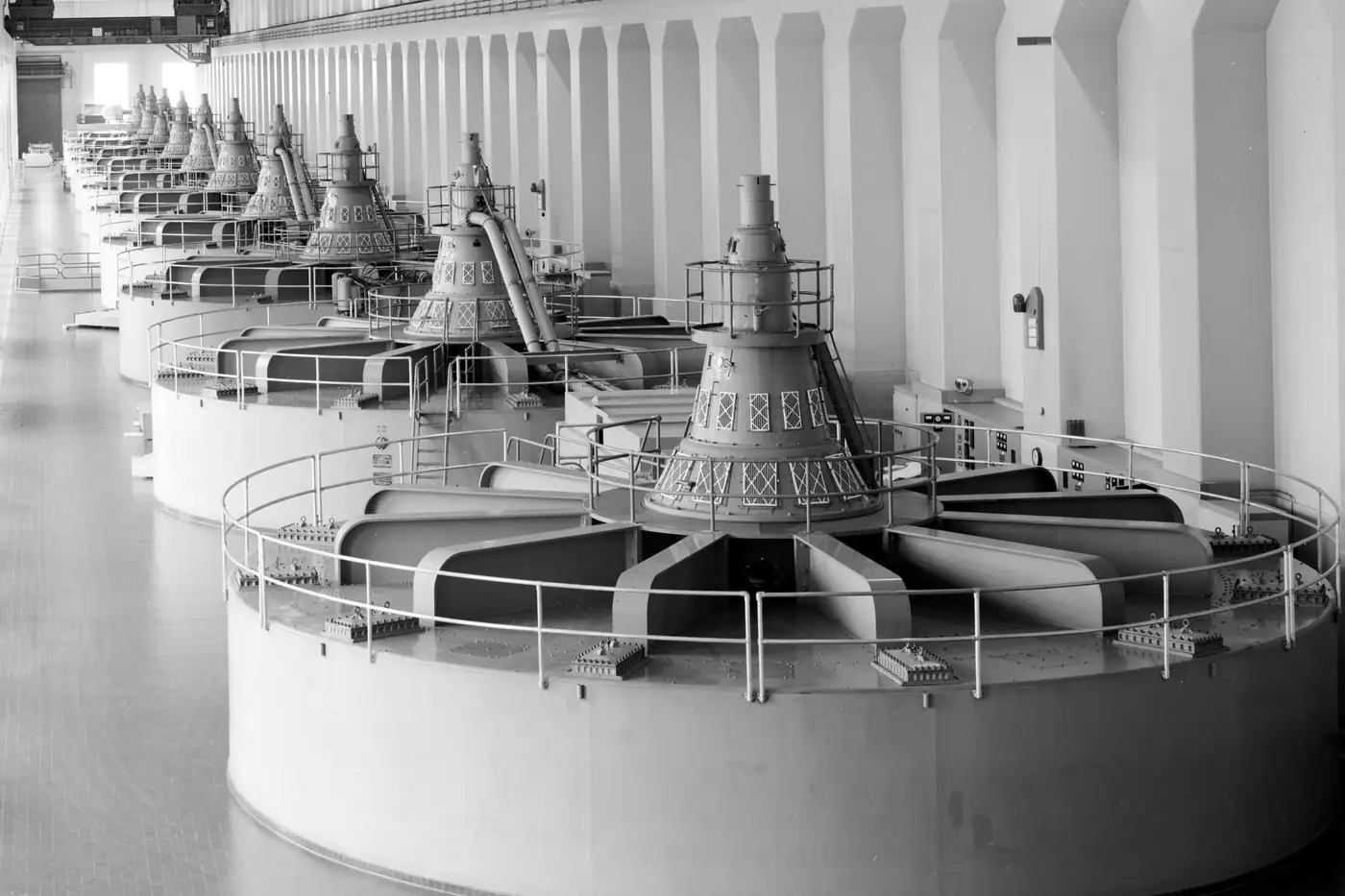 A row of turbine-generators on a powerhouse floor, from an archival engineering survey