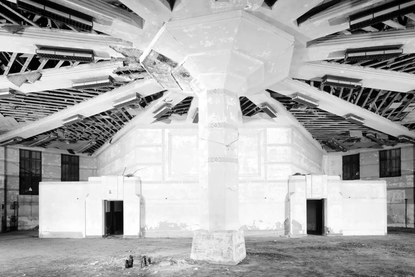 The stripped interior of a circular building, its roof framing radiating from a central column, from an archival building survey